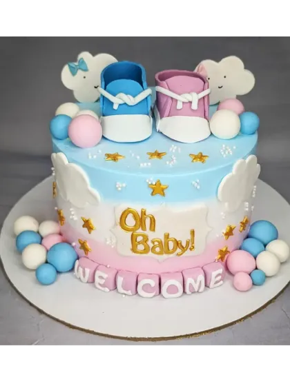 An adorable "Oh Baby!" welcome cake with a fresh mango flavor. The design includes pink and blue fondant baby shoes and fluffy clouds.