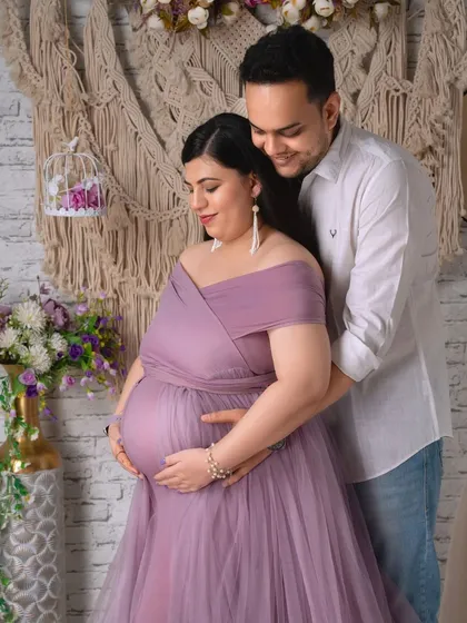 A sweet and intimate moment, with the husband-to-be embracing his wife from behind, both sharing a quiet moment looking at their future.