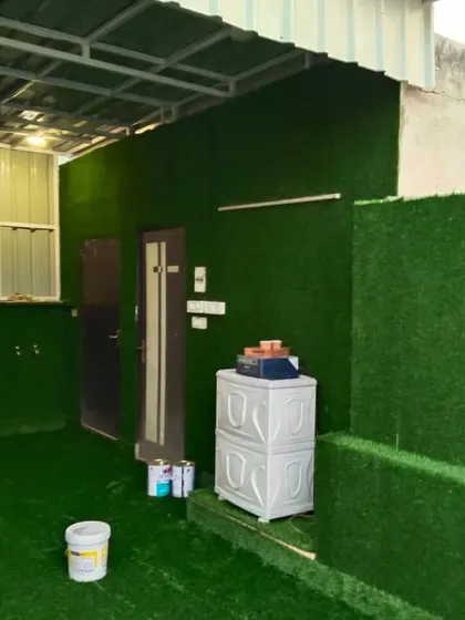 This entire covered outdoor space was transformed with artificial grass on both the floor and the walls, creating a fully green room.
