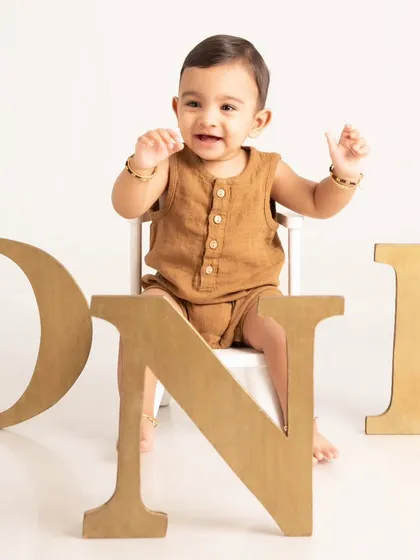 Celebrating a first birthday with a classic milestone portrait. This clean and simple setup with large "ONE" letters puts the focus entirely on your child's happy expression as they mark this special occasion.