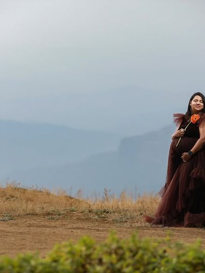 A breathtaking shot in the hills. This dark ruffled maternity gown creates a stunning contrast against the vast, open landscape, perfect for an adventurous mom-to-be.