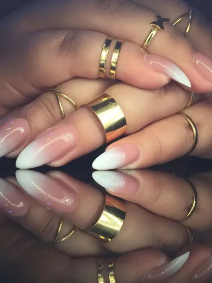 Another view of the stiletto baby boomer nails, accessorized with gold rings to highlight the design.