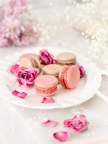A wider shot of the macaron setup, showing the full tablescape with lace and flowers, creating a complete, romantic story.