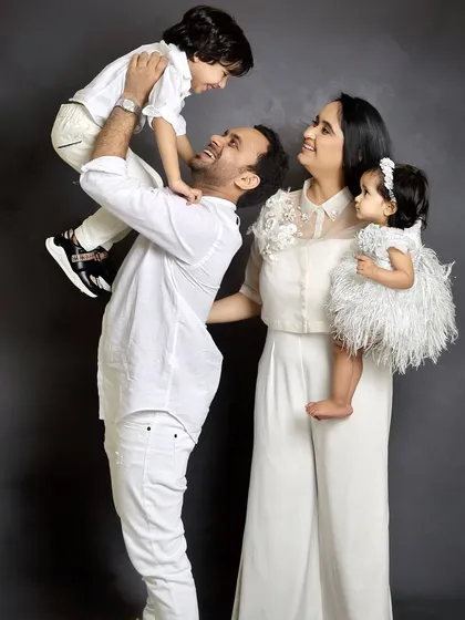 A playful family portrait that shows so much personality. The father lifting his son, the mother holding their daughter, everyone's expression is full of happiness.