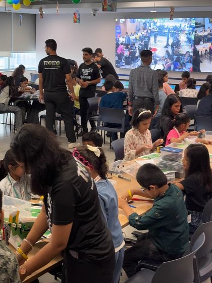 The view from the back of the room at the MetLife event shows the scale of our operation, with dozens of children and mentors engaged in various STEM activities.