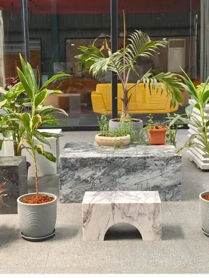 I can create unique, artistic focal points for your space. This modern arrangement uses a mix of textured pots and marble blocks to display a curated selection of plants, blending nature with contemporary design.