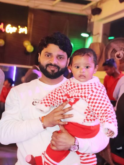 A candid portrait of a father and his baby at an evening event.