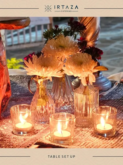 A close-up of a table centerpiece featuring fresh white chrysanthemums and tea lights. It's these small, thoughtful details that make a big difference in the overall event aesthetic.