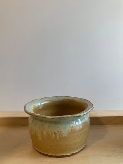 A wheel-thrown pot with a drippy, two-toned glaze. The way the colors melt together is a beautiful, unpredictable result of the firing process.