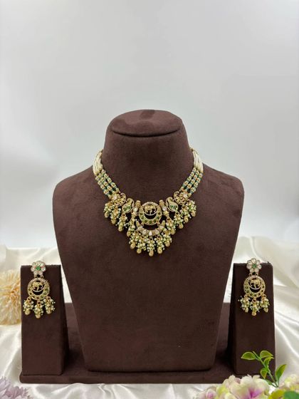 The "Royal Hathi" antique gold necklace set, shown in multiple color variations. This design features elephant motifs and is available with white, red, or multi-color stones, paired with a multi-strand pearl chain.