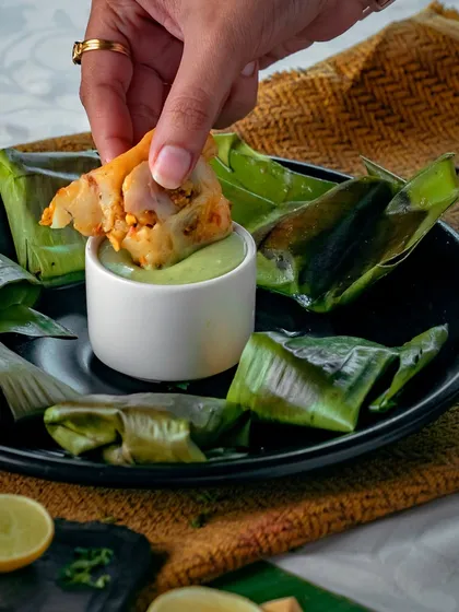 Experience a true coastal delicacy with our Pomfret steamed in banana leaves. The fish is marinated with subtle spices and lemon, then steamed to perfection, making it incredibly tender and aromatic.