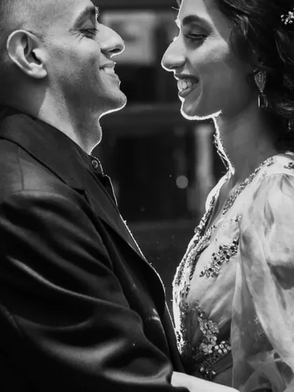 The power of a simple, quiet moment. This black and white portrait uses soft backlighting to highlight the couple's connection, creating a timeless and artistic photograph that feels like a still from a classic film.