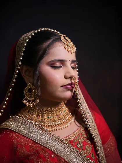 A close-up of a North Indian bridal look created by a student, focusing on the rich eye makeup and jewelry.