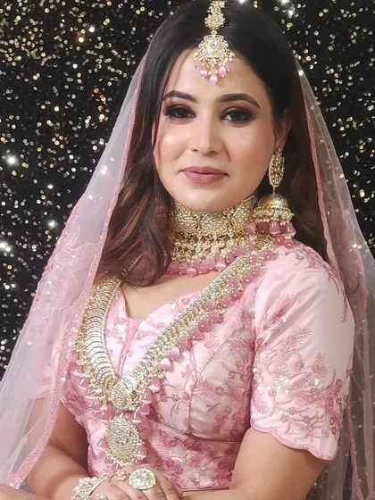 A model in a lovely pink lehenga, showcasing a complete look perfect for a makeup artist's portfolio.