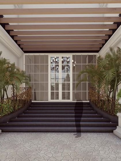 The Clarence is a pristine home designed with classical elegance for two brothers. The entrance features a stately staircase and a wooden pergola, framed by classical columns and lanterns, creating a welcoming yet majestic facade.