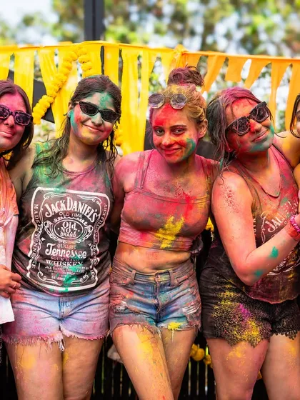 A group of friends covered in colors at our Goa Holi party. We focus on creating a fun and safe environment where everyone can enjoy the festival of colors.