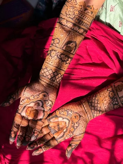This bridal mehendi features beautiful portraits of the couple in traditional attire, framed by intricate patterns.