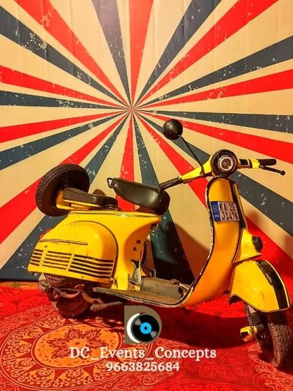 We love creating fun and unique photo opportunities. This retro-themed entrance features a vintage scooter against a vibrant backdrop, serving as a quirky and memorable welcome prop.