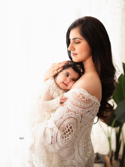 A tender portrait of a mother holding her baby girl close.