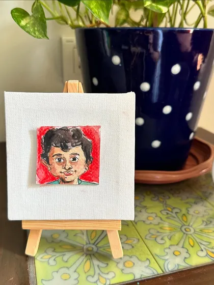 My mini portrait of Mahir on an easel.