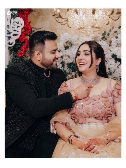 A candid and happy moment from a Roka ceremony. The groom's playful gesture and the bride's joyful laugh make this a heartwarming memory.