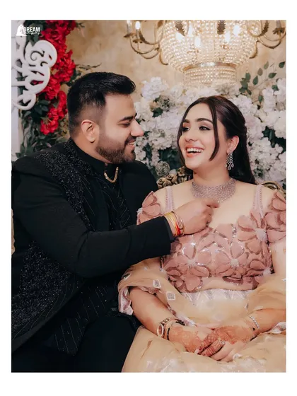 A candid and happy moment from a Roka ceremony. The groom's playful gesture and the bride's joyful laugh make this a heartwarming memory.