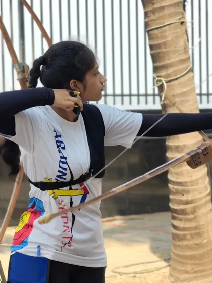 A young girl at full draw, showing strength and focus. We are building future champions.