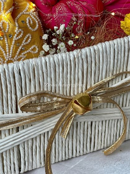 The details matter. This close-up of the white Lohri basket shows the delicate golden bow with a small bell, adding a charming touch to the overall design.