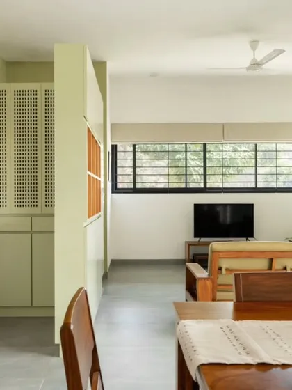 A view from the dining area towards the living room and foyer. The open-plan layout creates a fluid, interconnected ground floor, while a storage unit doubles as a subtle visual divider.