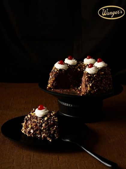 Our Hazelnut Chocolate Cake, with its rich dark chocolate, crunchy nougat, and a cherry on top. It's a sophisticated dessert, perfect for a special occasion.