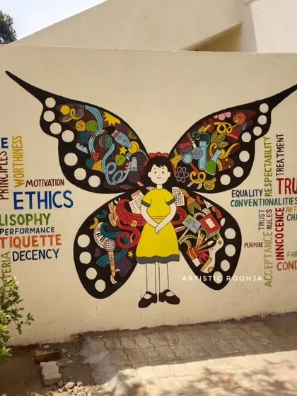 A completed butterfly mural where the wings are filled with words related to ethics and values, like "Truth," "Respect," and "Innocence."