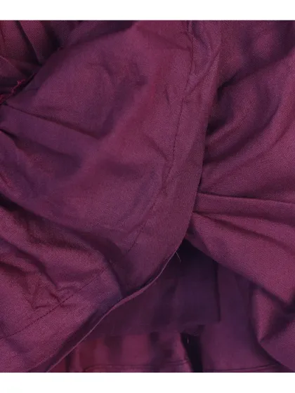 An inside-out detail shot of a purple baby dress, showing the quality of the inner fabric and seams.