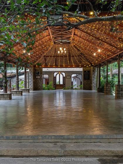 The main hall, with its high, wood-beamed ceiling covered in fairy lights, ready to host a grand Sangeet or reception.