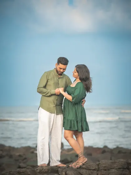 A tender pre-wedding portrait by the sea. The way he holds her hand and looks at her shows the deep connection and affection between them.