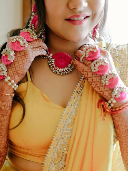 A close-up of a Haldi bride's details. The look features fresh, dewy skin and beautiful floral jewellery that is perfect for the occasion.