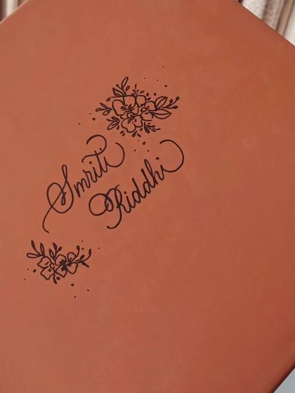 The gift box for the personalized mugs, itself personalized with the names 'Smriti' and 'Riddhi' and floral illustrations. The experience of a gift begins with the packaging.