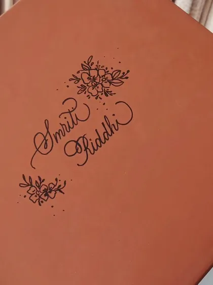 The gift box for the personalized mugs, itself personalized with the names 'Smriti' and 'Riddhi' and floral illustrations. The experience of a gift begins with the packaging.
