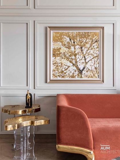 Lost in a symphony of elegance. This salmon-colored sofa with opulent gold legs sits beside custom tables, creating a corner of pure glamour in a 3800 sq. ft. Mumbai home.