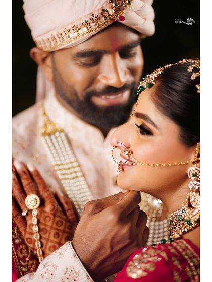 An intimate close-up of the groom gently touching the bride's chin. This tender gesture and their soft expressions make for a deeply romantic photograph.