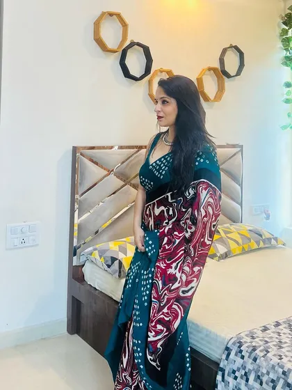A side profile showing how the printed saree drapes. The combination of the bandhani-style dots on the body and the abstract print on the pallu offers a unique design that is both traditional and modern.