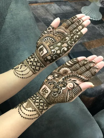 A modern and chic design featuring the couple's initials on the back of the hands, surrounded by delicate beaded chains.