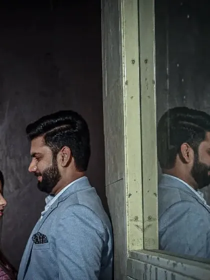 An artistic portrait using a mirror to capture the couple's reflection, adding depth and a creative angle to the shot.