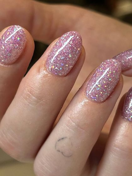 A fun and feminine pink glitter manicure. The light-reflecting particles create a dazzling sparkle that is perfect for parties or any time you want to shine.