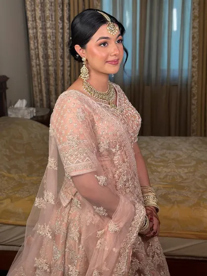 A three-quarter profile showing off the radiant skin and elegant updo. This look is all about a mesmerizing, royal glow.
