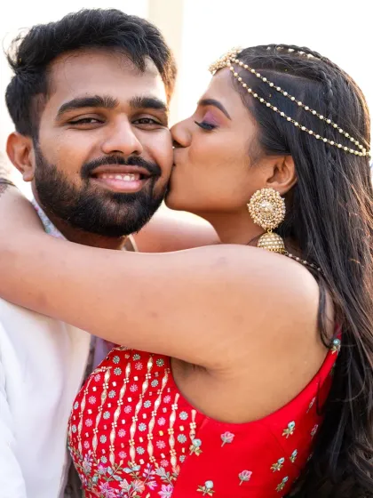 A sweet kiss on the cheek. This close-up captures the affection and the beautiful details of the bride's Mehendi jewelry.