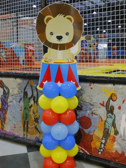 A cute lion on a circus stand, part of a carnival-themed party decor. The primary colors create a classic and cheerful circus atmosphere.
