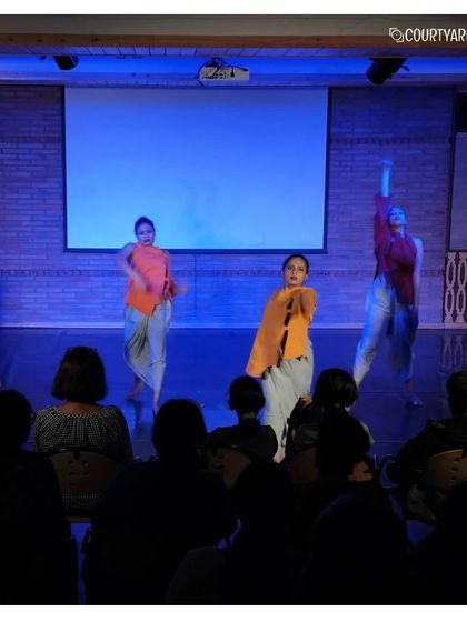 A dynamic and colourful scene from the Attakkalari performance, blending contemporary costumes with traditional movements.