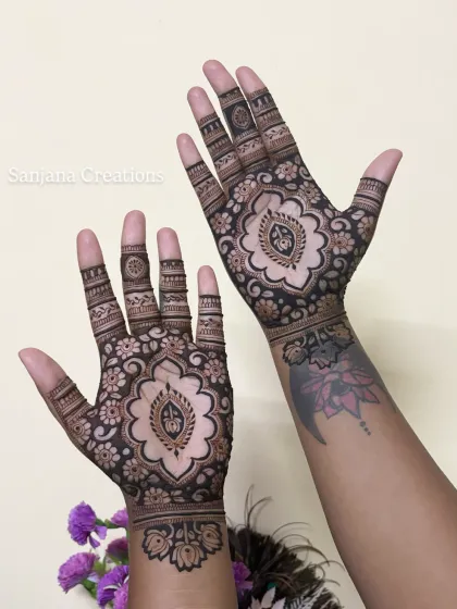 Both hands together, showing how the cutwork design complements the client's existing tattoo.