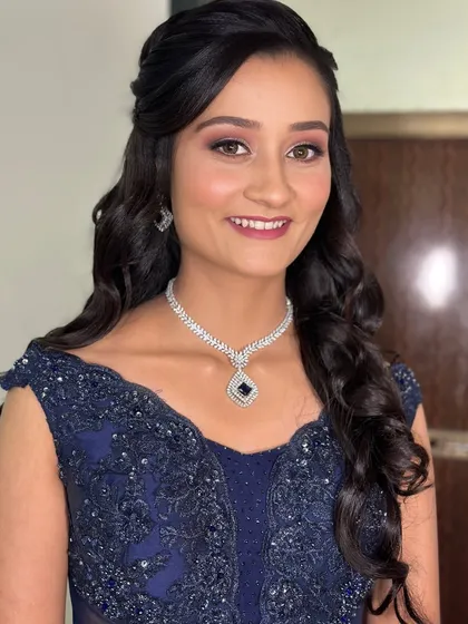 A classic party look with a navy blue gown, soft smokey eyes, and a radiant smile.