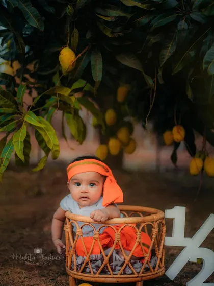 This little one is celebrating his half-birthday in style, surrounded by nature and fresh mangoes.